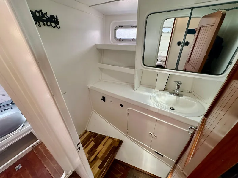 Slide: The Image of Bathroom interior of 1983 Tayana 55 yacht with sink, mirror, and wooden flooring. - 36