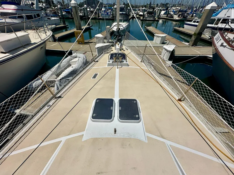 Slide: The Image of Deck view of 1983 Tayana 55 sailboat docked in a marina. - 38