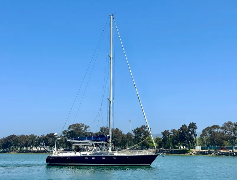 Slide: The Image of 1983 Tayana 55 sailboat on calm water with clear blue sky background. - 4