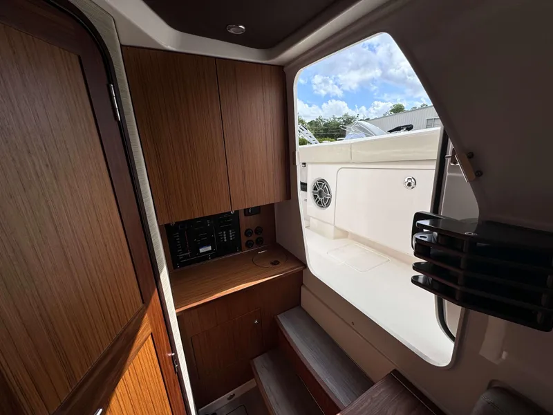 Slide: The Image of Interior view of 2025 Solace 41 CS boat with wooden cabinetry and open door to deck. - 34
