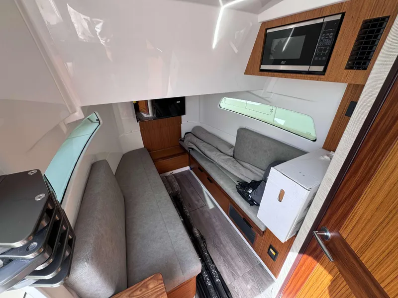 Slide: The Image of Interior of 2025 Solace 41 CS boat with modern seating, microwave, and wooden accents. - 35