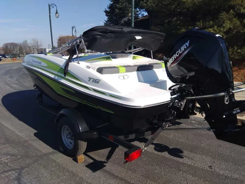 Slide: The Image of 2024 Tahoe T16 boat with Mercury engine on a trailer, parked outdoors. - 4