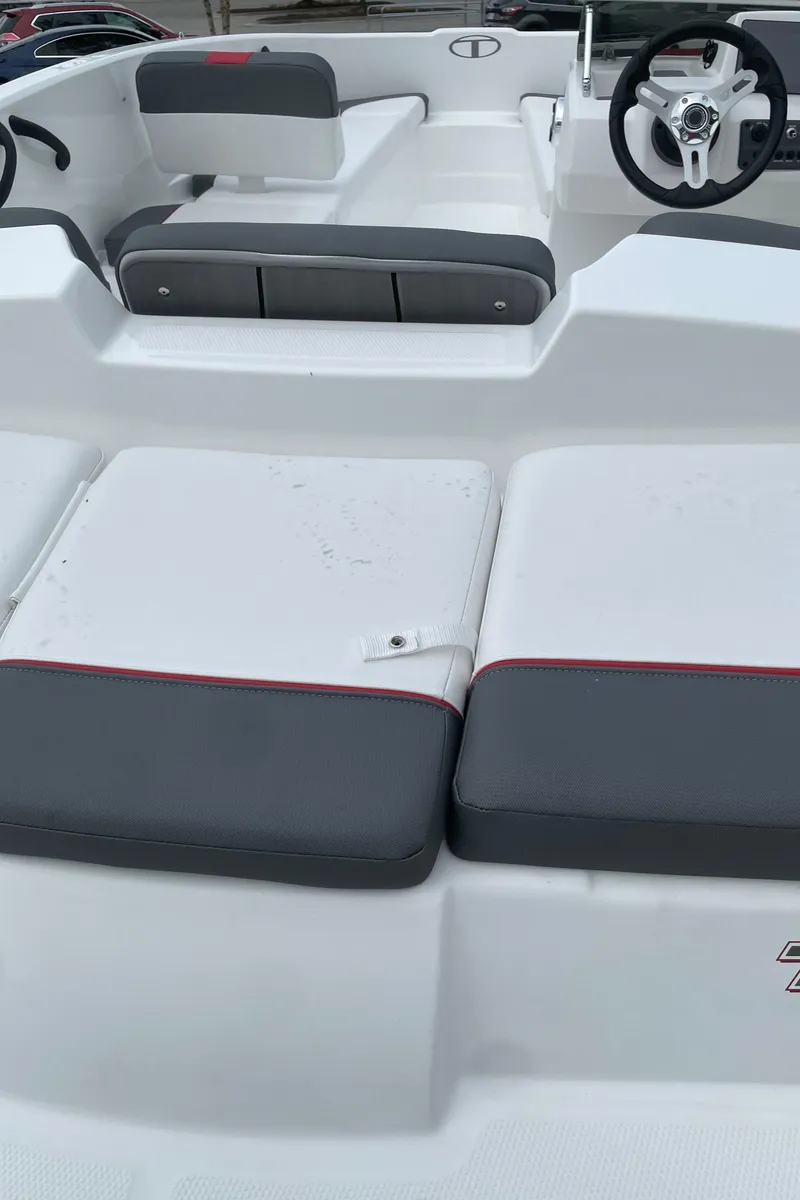 Slide: The Image of 2024 Tahoe T16 boat interior with gray and white seating, steering wheel, and dashboard. - 2