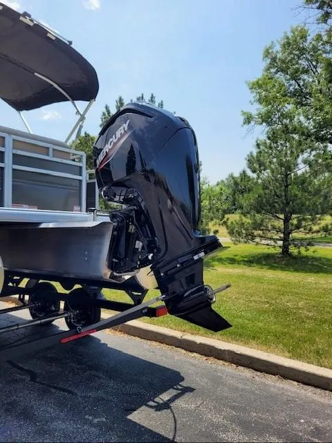 Slide: The Image of 2024 Sun Tracker Party Barge 20 DLX with Mercury outboard motor on trailer. - 2