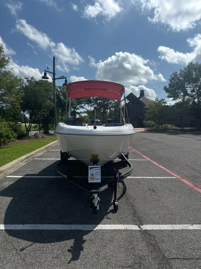 Slide: The Image of 2024 Tahoe T18 boat with red canopy on trailer in parking lot. - 3