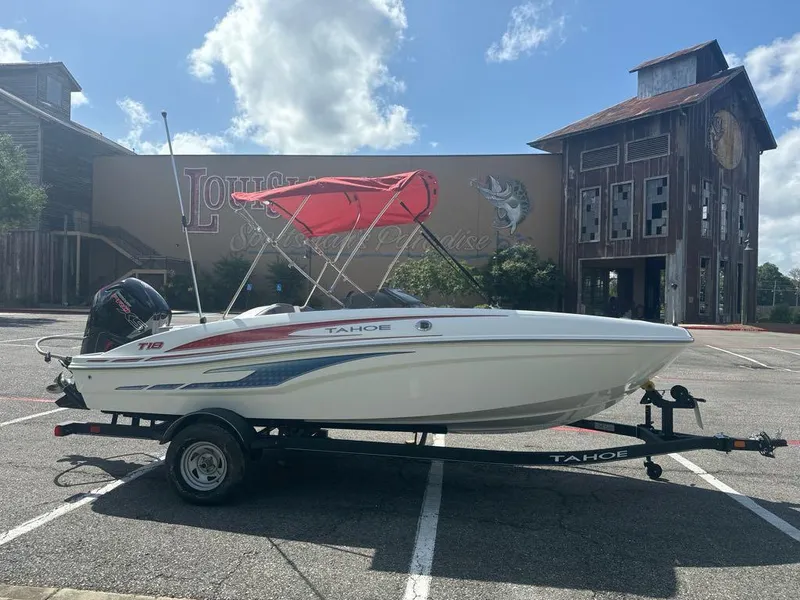 Slide: The Image of 2024 Tahoe T18 boat with red canopy on trailer in parking lot. - 4