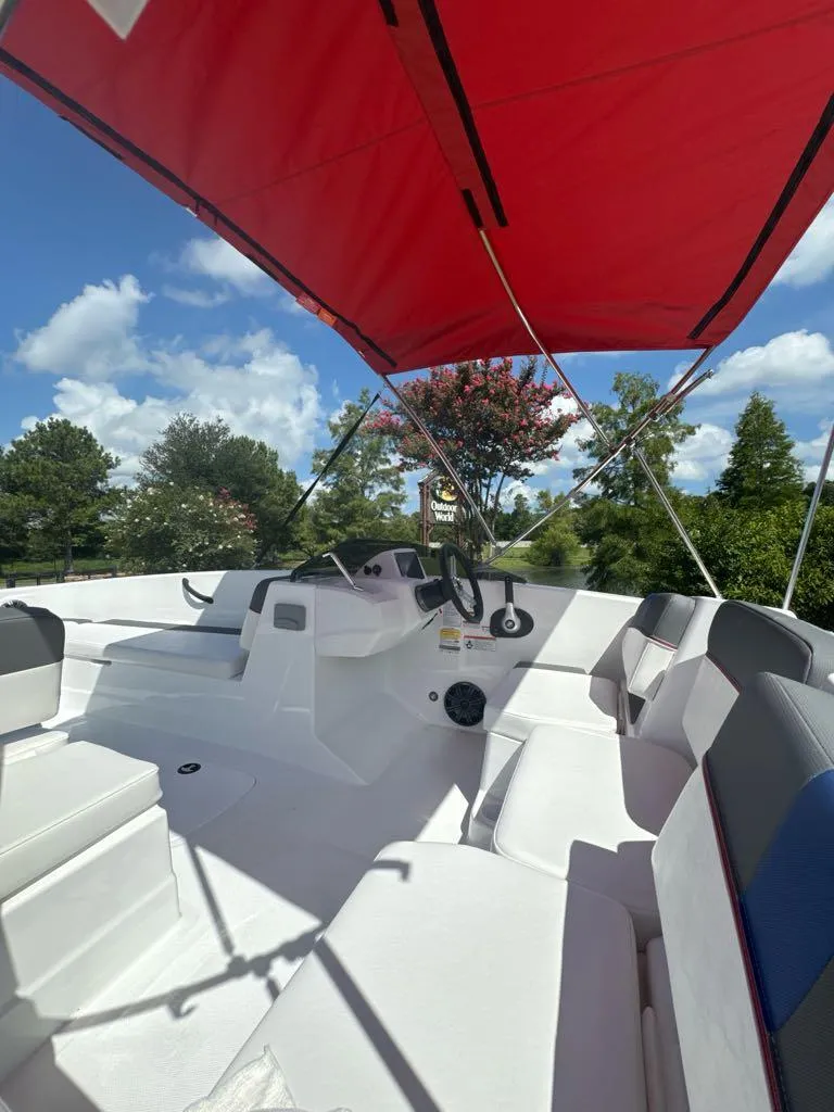 Slide: The Image of 2024 Tahoe T18 boat interior with red canopy, white seating, and steering console. - 6
