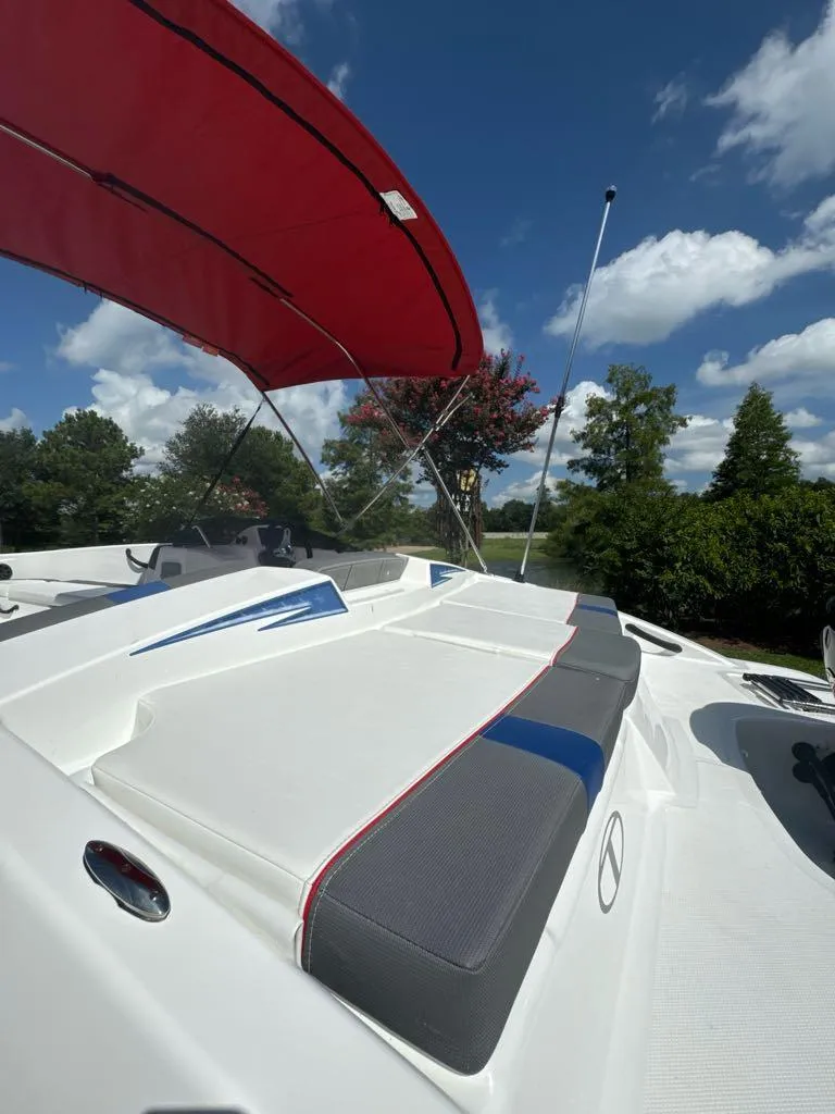Slide: The Image of 2024 Tahoe T18 boat with red canopy and cushioned seating. - 7