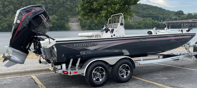 Slide: The Image of 2024 Ranger RB210 boat on trailer by a river, featuring sleek design and powerful engine. - 3