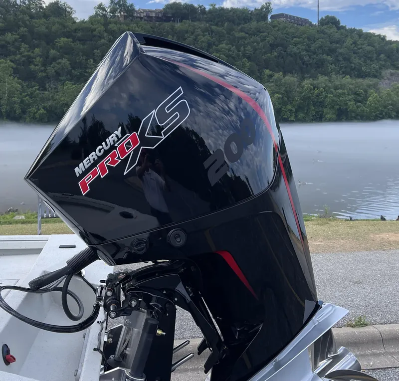 Slide: The Image of 2024 Ranger RB210 with Mercury Pro XS outboard motor by a scenic lake. - 5