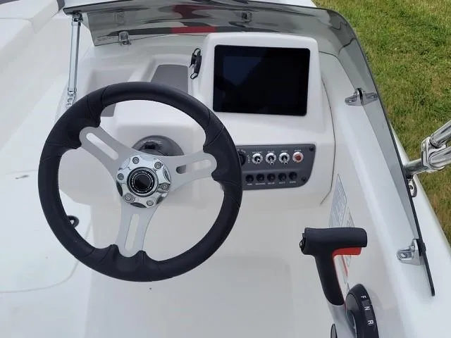 Slide: The Image of 2024 Tahoe T16 boat dashboard with steering wheel, control panel, and touchscreen display. - 3