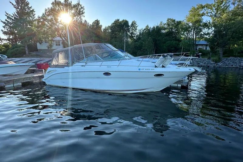 Slide: The Image of 2003 Sea Ray 290 Amberjack boat docked on calm water at sunset. - 0