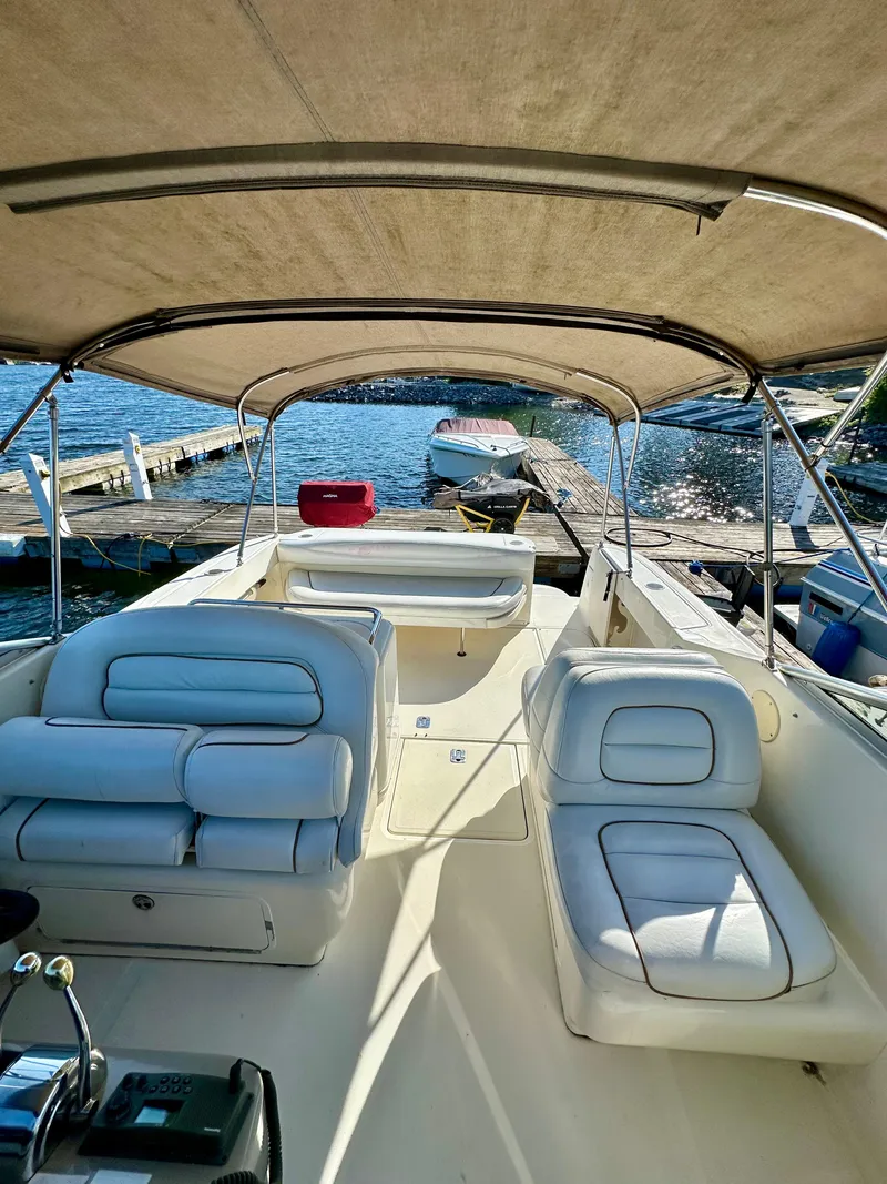 Slide: The Image of 2003 Sea Ray 290 Amberjack boat interior with seating, docked by the water. - 1