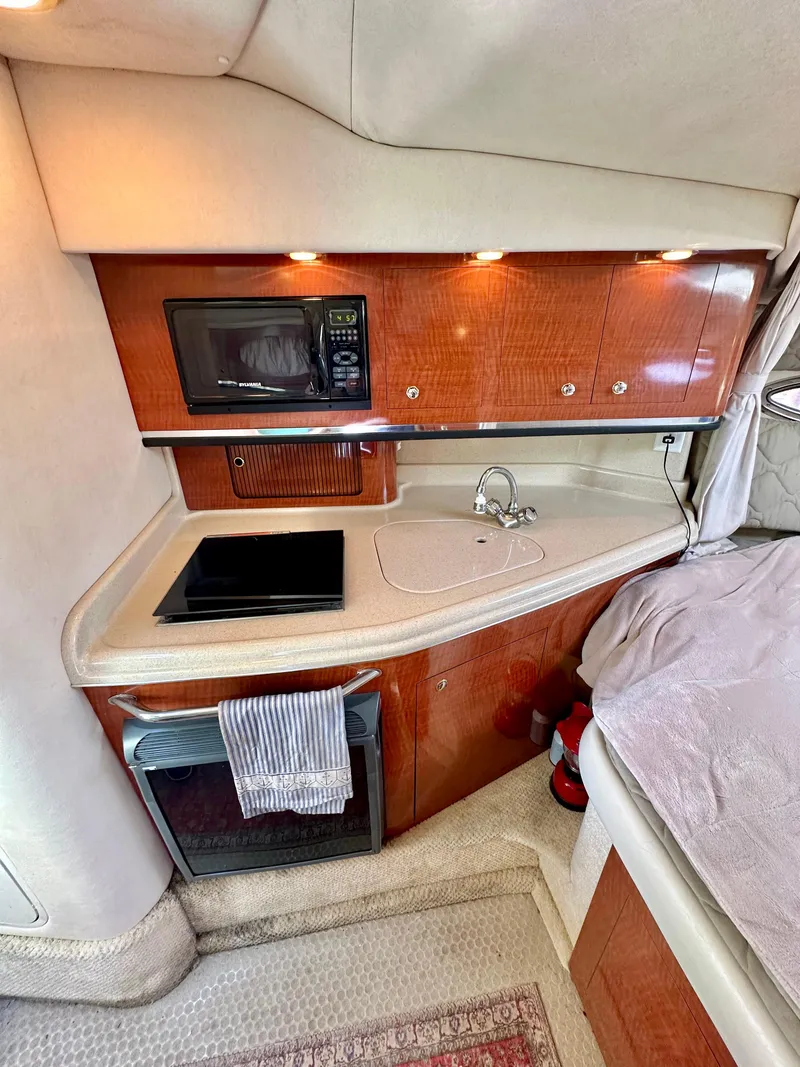 Slide: The Image of 2003 Sea Ray 290 Amberjack cabin with kitchenette, microwave, and sink. - 13