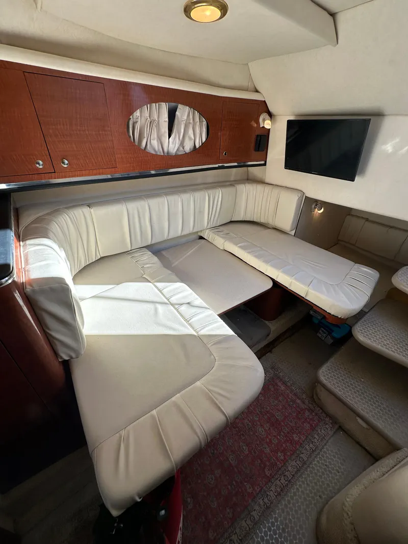 Slide: The Image of Interior of 2003 Sea Ray 290 Amberjack with white leather seating and wall-mounted TV. - 15