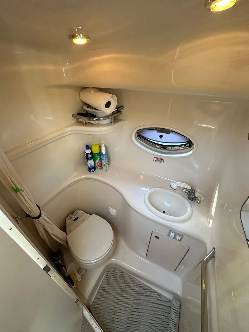 Slide: The Image of 2003 Sea Ray 290 Amberjack bathroom with toilet, sink, and storage shelves. - 17
