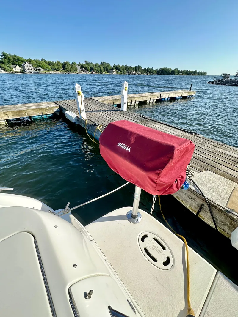 Slide: The Image of 2003 Sea Ray 290 Amberjack docked by a serene lake with clear blue skies. - 23