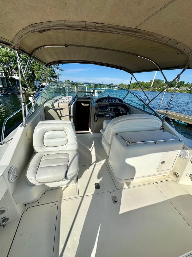 Slide: The Image of 2003 Sea Ray 290 Amberjack boat interior with seating and helm, docked by the water. - 4