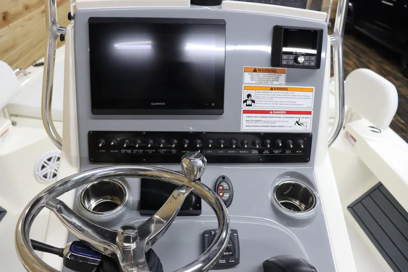 Slide: The Image of 2024 Pathfinder 2200 TRS boat dashboard with steering wheel, control panel, and display screen. - 14