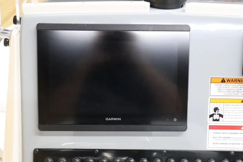 Slide: The Image of Garmin display on 2024 Pathfinder 2200 TRS boat dashboard with warning labels. - 16
