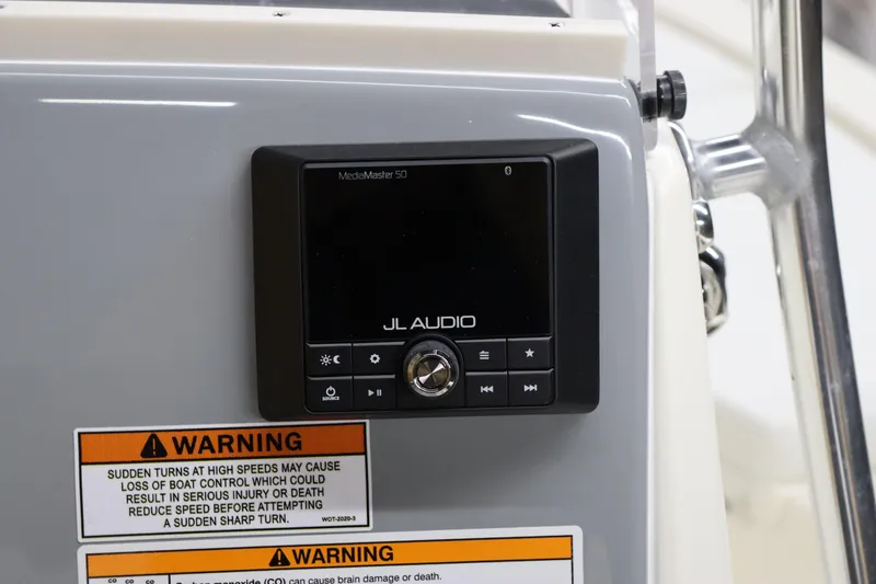 Slide: The Image of 2024 Pathfinder 2200 TRS boat dashboard with JL Audio system and warning labels. - 17
