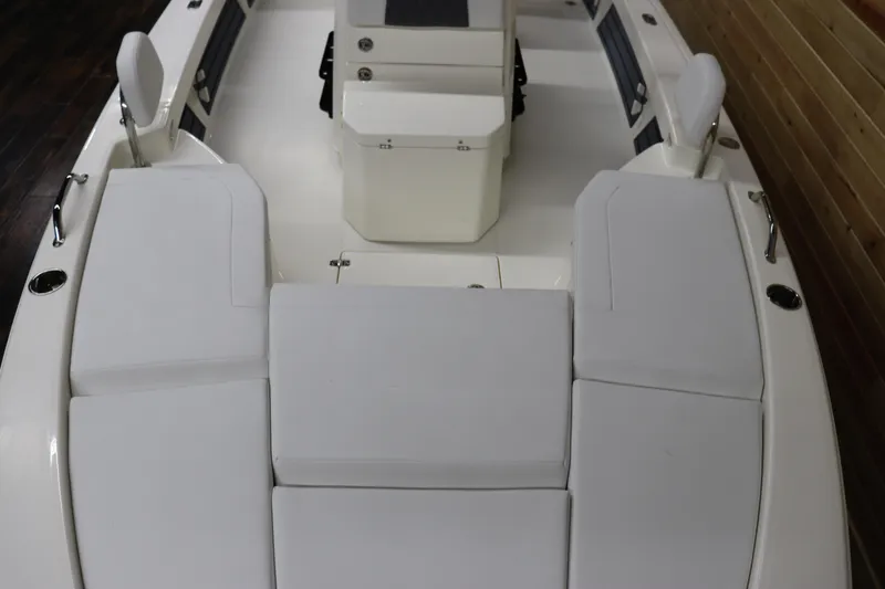 Slide: The Image of 2024 Pathfinder 2200 TRS boat interior with white cushioned seating and storage compartments. - 8