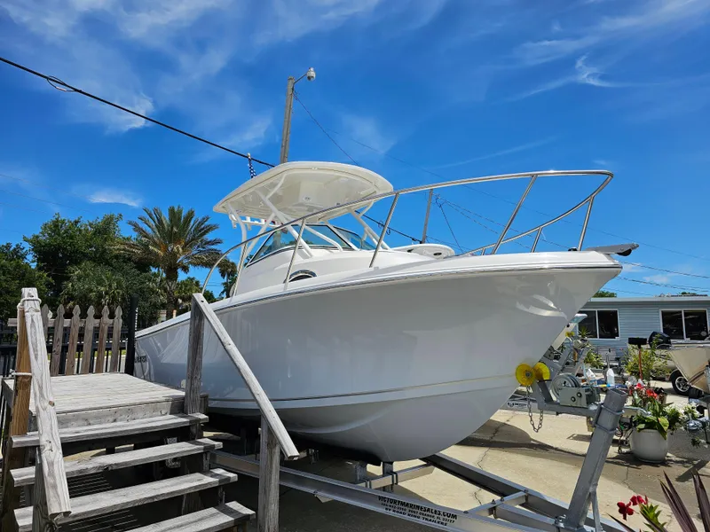 Slide: The Image of 2024 Sailfish 220 WAC boat on trailer under clear blue sky. - 10