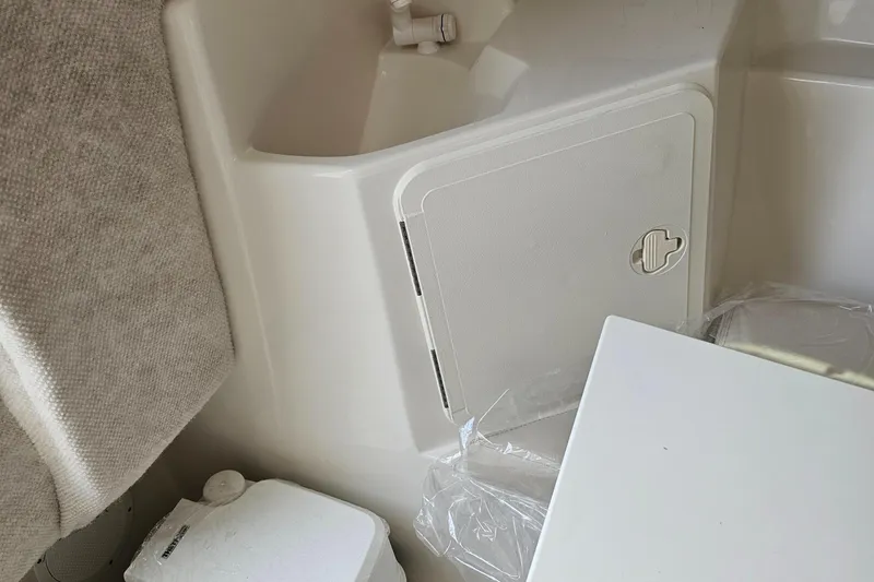 Slide: The Image of 2024 Sailfish 220 WAC cabin interior with storage compartment and seating area. - 13