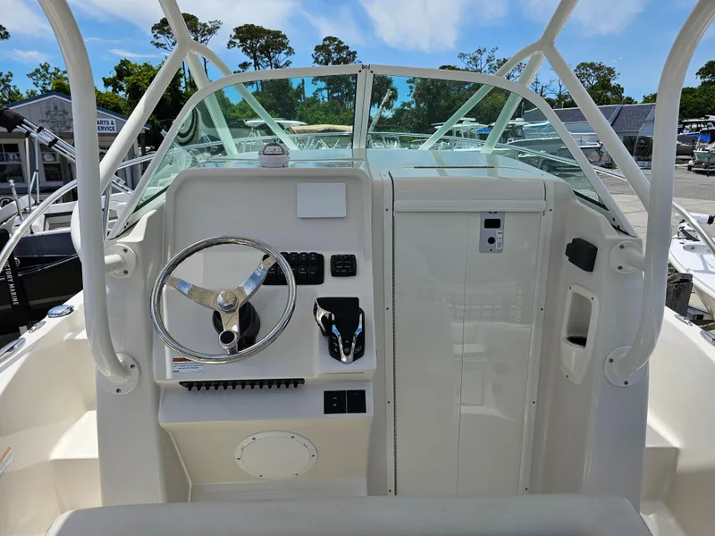 Slide: The Image of 2024 Sailfish 220 WAC boat helm with steering wheel and control panel. - 3