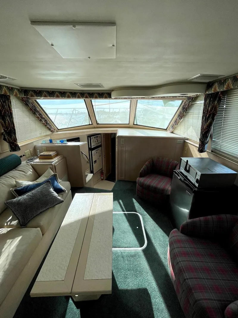 Slide: The Image of Interior of 1991 Hatteras 40 Motor Yacht with seating, table, and large windows. - 13