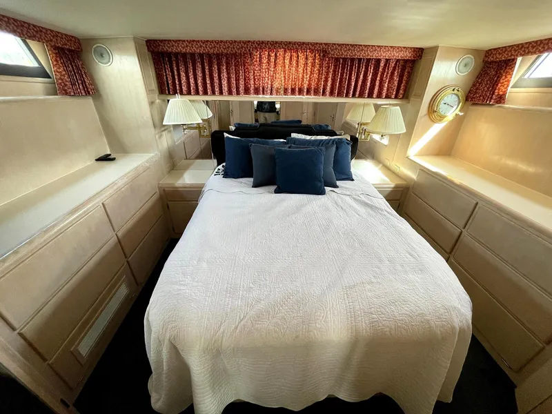 Slide: The Image of Interior of 1991 Hatteras 40 Motor Yacht bedroom with bed, lamps, and storage. - 14