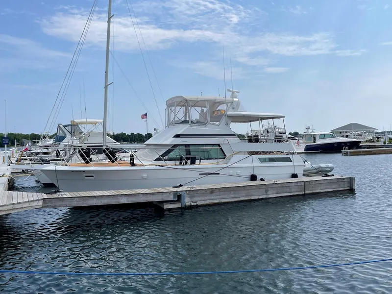Slide: The Image of 1991 Hatteras 40 Motor Yacht docked at a marina under a clear blue sky. - 19