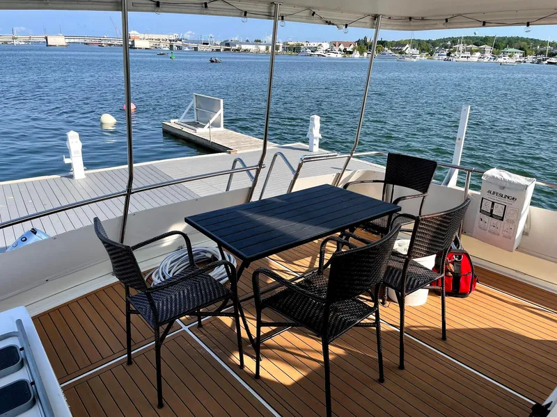 Slide: The Image of Outdoor seating on 1991 Hatteras 40 Motor Yacht, overlooking marina with dock and calm waters. - 2