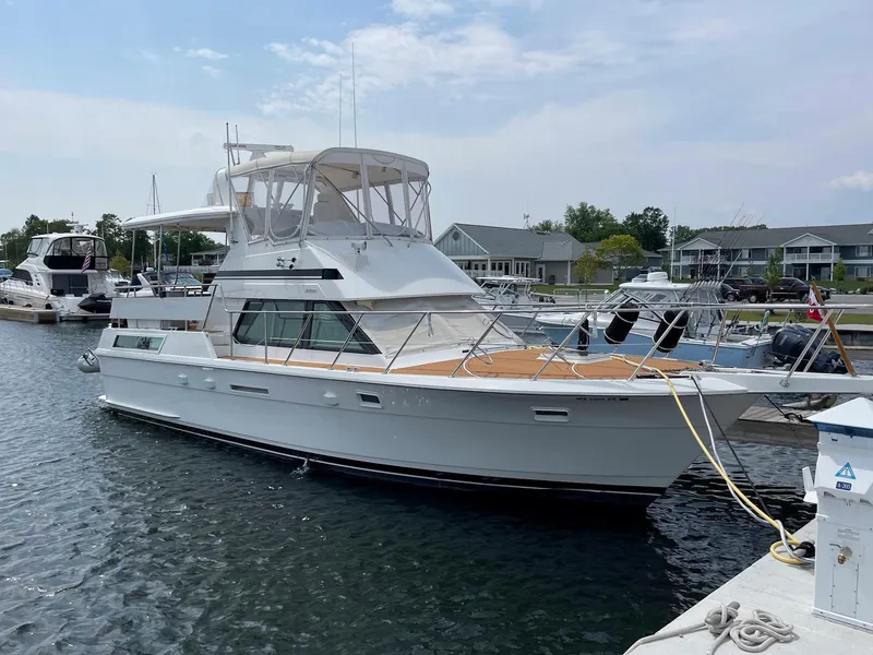 Slide: The Image of 1991 Hatteras 40 Motor Yacht docked at a marina under a clear sky. - 21