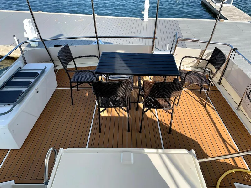 Slide: The Image of 1991 Hatteras 40 Motor Yacht deck with seating and table, overlooking marina. - 7