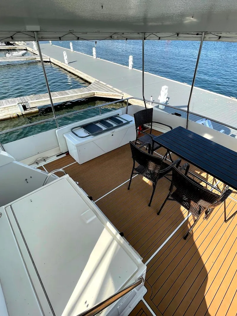 Slide: The Image of 1991 Hatteras 40 Motor Yacht deck with seating and marina view. - 8