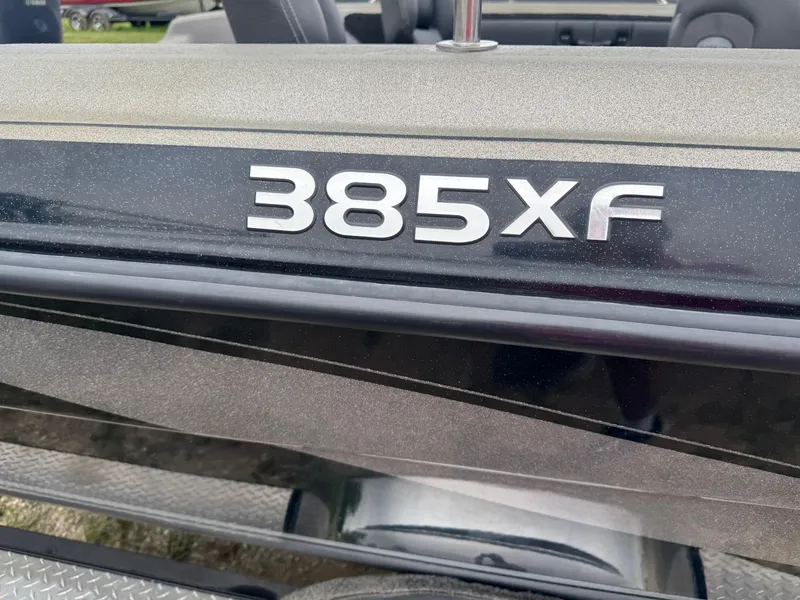 Slide: The Image of 2014 Stratos 385 XF boat model emblem on sleek black surface. - 3