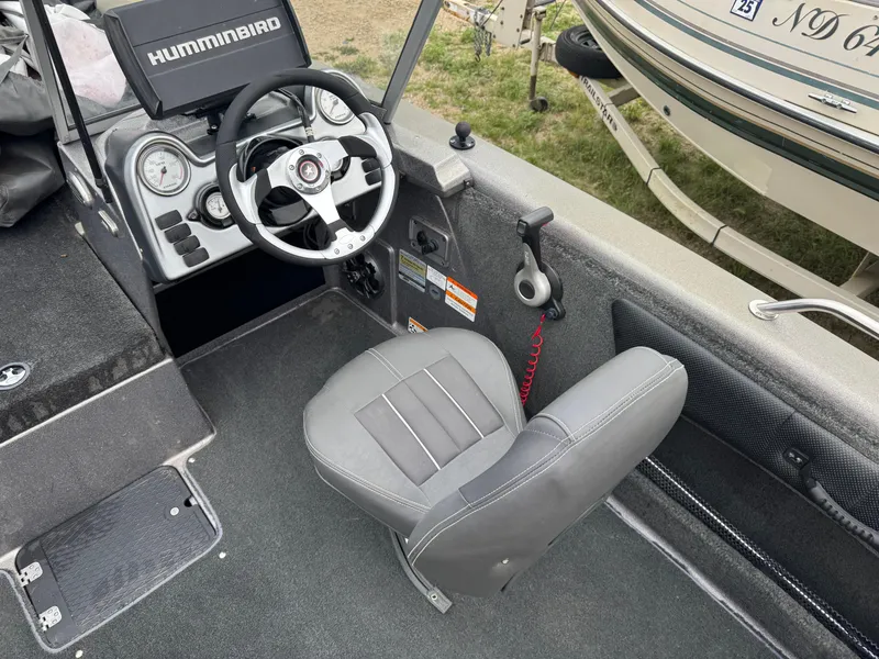 Slide: The Image of Interior of a 2014 Stratos 385 XF boat with steering wheel and Humminbird display. - 8