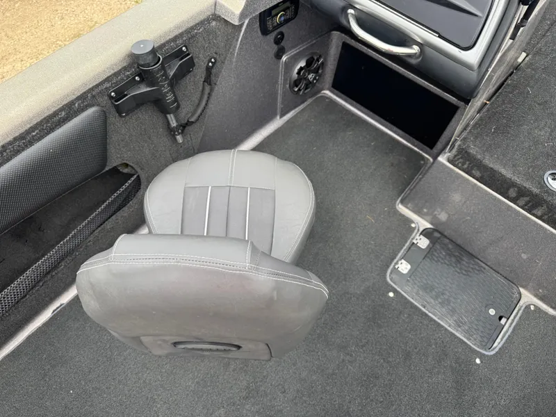 Slide: The Image of Interior of a 2014 Stratos 385 XF boat featuring a gray seat and storage compartments. - 9