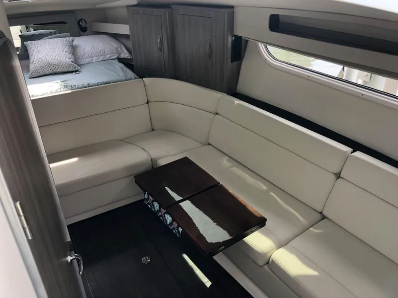 Slide: The Image of Interior of 2020 Regal 35 Sport Coupe with white leather seating and wooden table. - 20