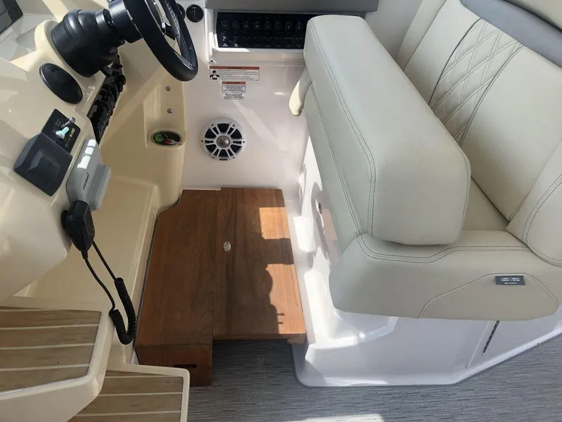 Slide: The Image of Helm station of 2020 Regal 35 Sport Coupe with beige seating and wooden flooring. - 27