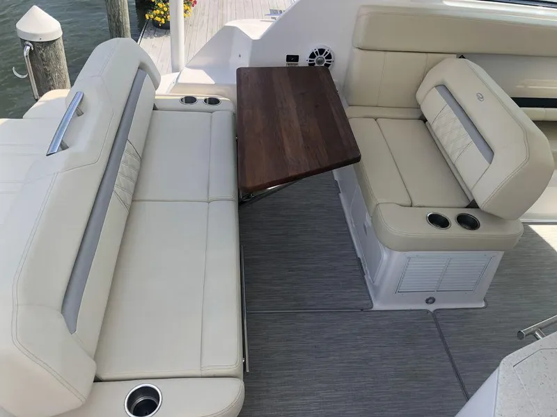Slide: The Image of 2020 Regal 35 Sport Coupe interior seating with wooden table and cup holders. - 28