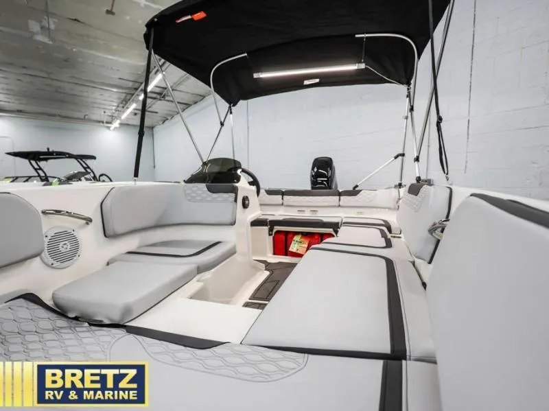 Slide: The Image of 2024 Element M15 boat interior with cushioned seating and canopy at Bretz RV & Marine showroom. - 15