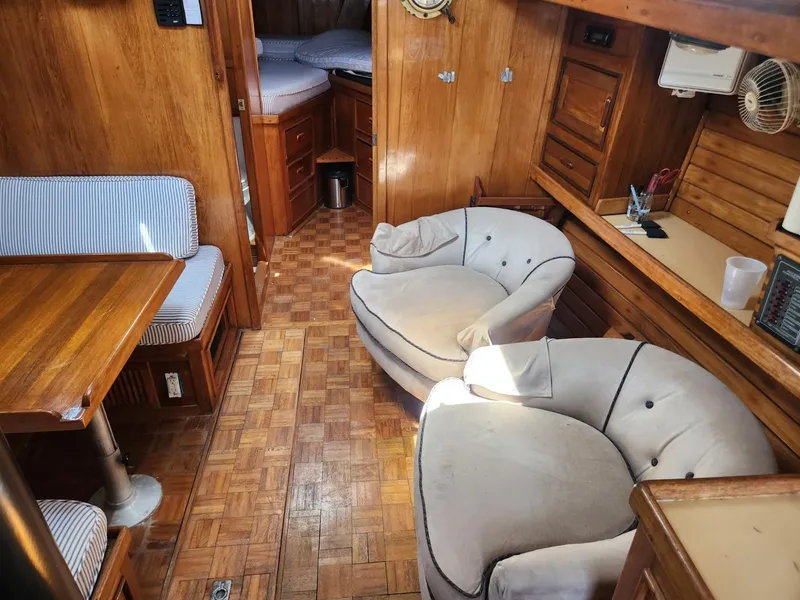 Slide: The Image of Interior of 1985 Herreshoff 38 Cat Ketch with wooden furnishings and cozy seating. - 12