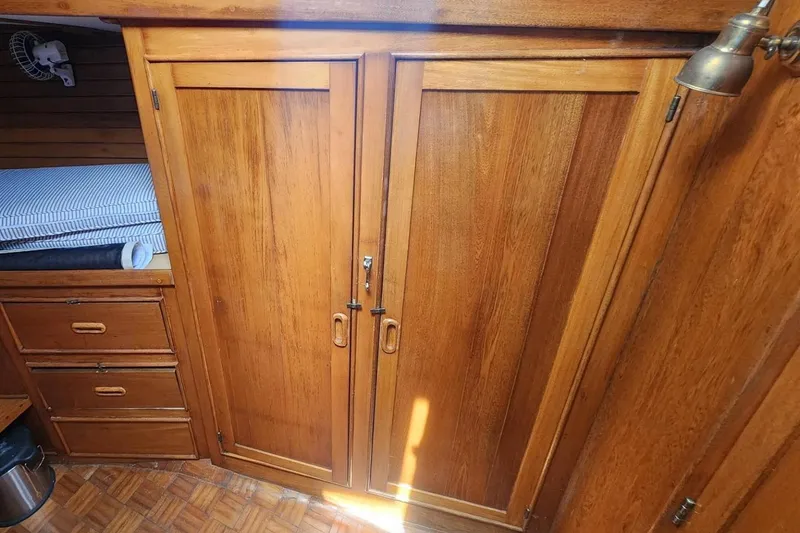 Slide: The Image of Interior cabin of 1985 Herreshoff 38 Cat Ketch with wooden cabinetry and bunk bed. - 26