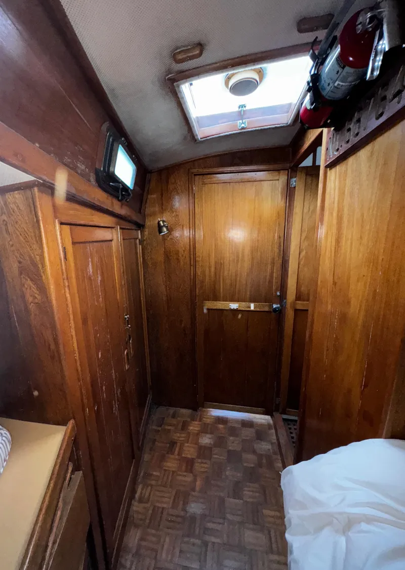 Slide: The Image of Interior of 1985 Herreshoff 38 Cat Ketch with wooden paneling and skylight. - 27