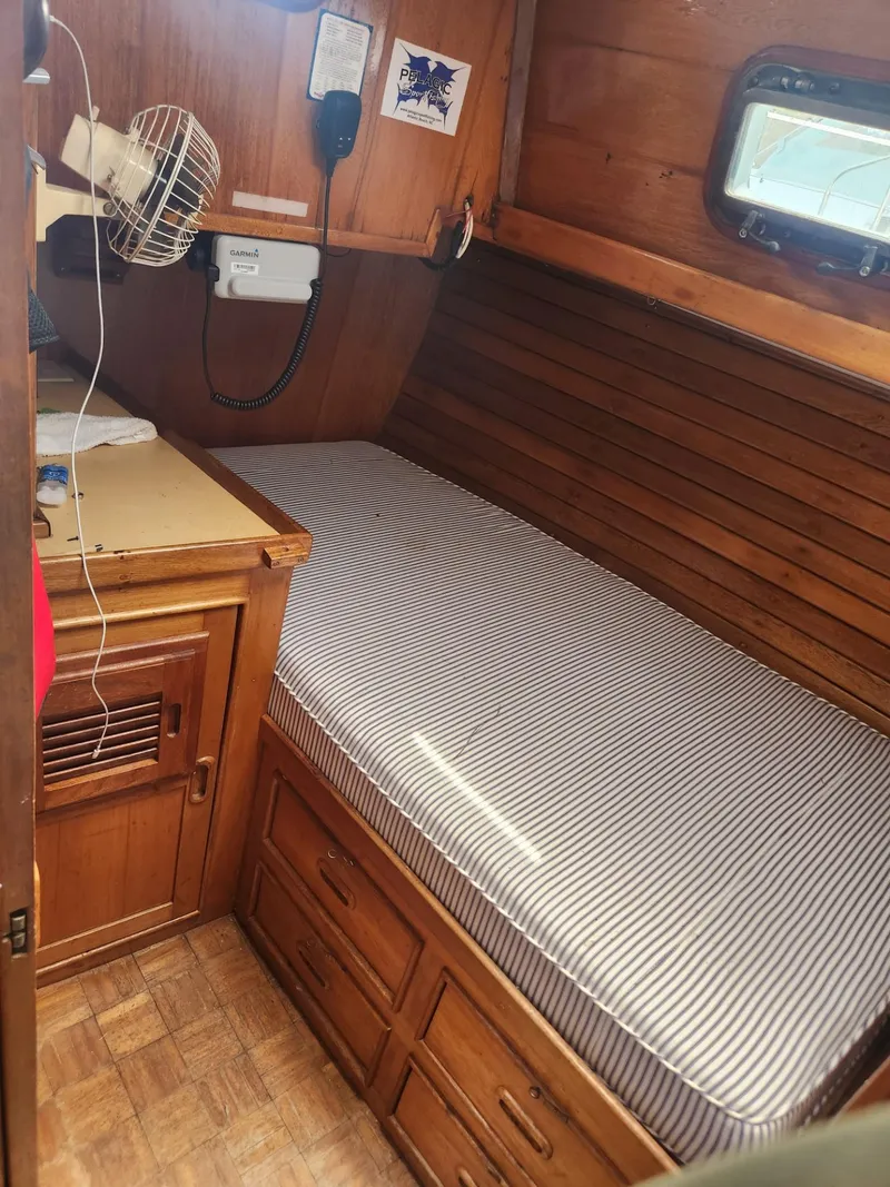 Slide: The Image of 1985 Herreshoff 38 Cat Ketch cabin with wooden interior and single bed. - 28