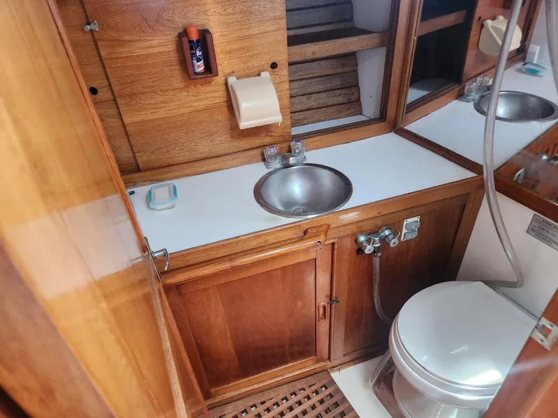Slide: The Image of 1985 Herreshoff 38 Cat Ketch bathroom with wooden cabinetry and stainless steel sink. - 34