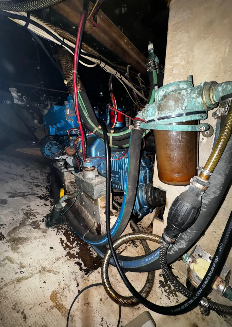Slide: The Image of Engine room of 1985 Herreshoff 38 Cat Ketch with visible machinery and hoses. - 41