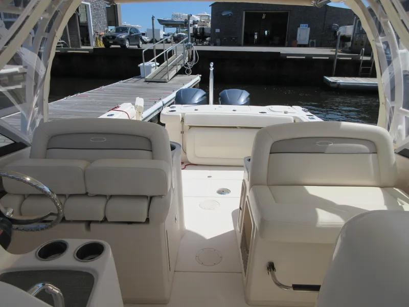 Slide: The Image of 2016 Grady-White Freedom 307 boat interior at dock, featuring comfortable seating and dual outboard motors. - 12